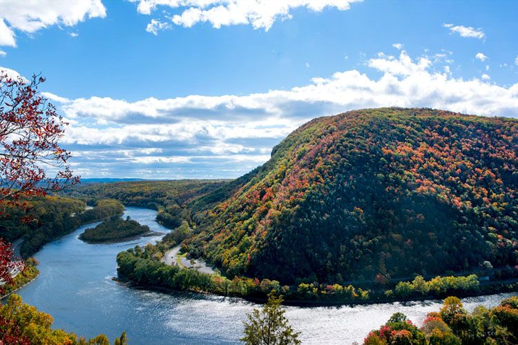 A breathtaking view of Delaware Water Gap, featuring dramatic cliffs rising above a winding river, showcasing the natural beauty of the area. Must-See Places in Pennsylvania