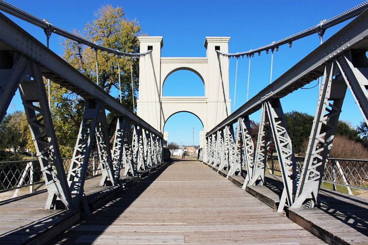 Visit Waco Suspension Bridge: An iconic Texas landmark spanning the Brazos River, perfect for scenic walks, photos, and historic charm. What to do in Waco, Texas Waco Suspension Bridge